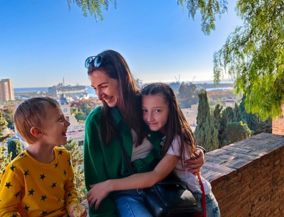 a woman and two children sitting on a bench